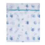 A reusable white mesh laundry bag with a blue tropical leaf print and zippered closure helps protect delicate garments during machine washing.