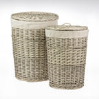 Set of two rectangular wicker laundry hampers with woven lids, natural fabric linings, and natural wicker finishes, displayed against a light grey background.