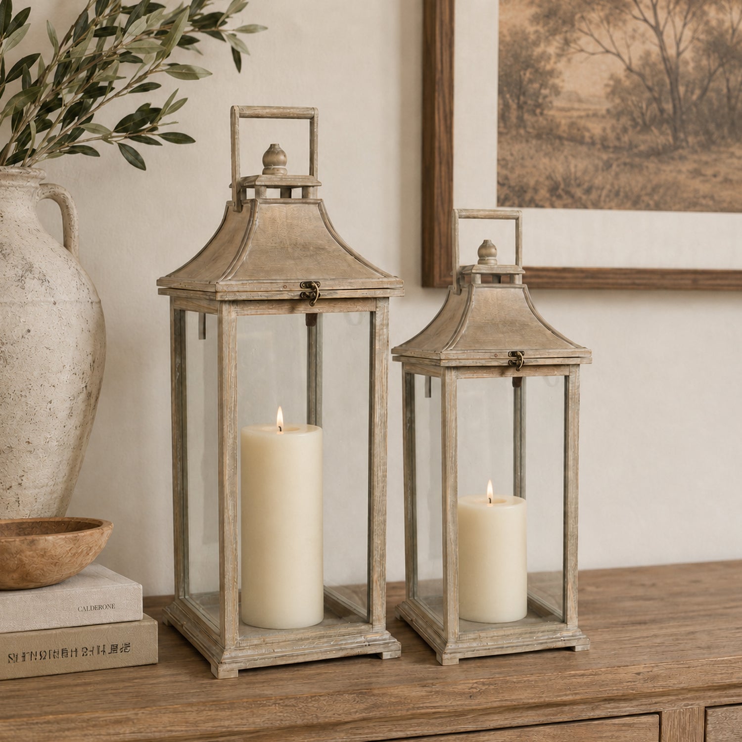 Design Republique Ivona Garden Candle Lanterns 2 Piece Natural styled on a wooden console with lit pillar candles inside.
