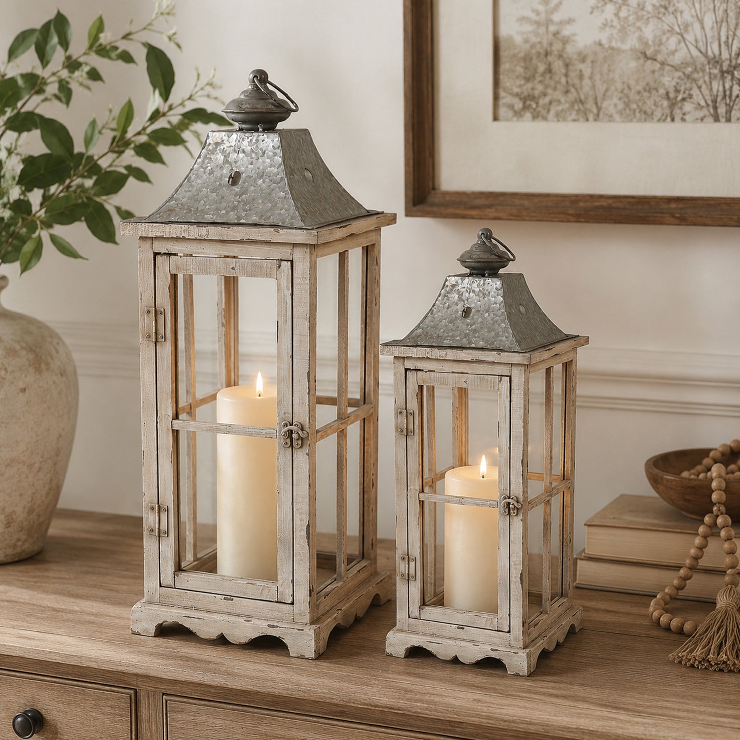 Design Republique Ivona Garden Candle Lanterns 2 Piece Natural styled on a wooden console with lit pillar candles inside.