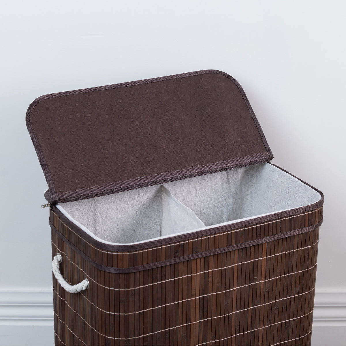 Design Republique Ranger Double Bamboo Hamper in Walnut, angled view with the lid open to reveal two separate fabric-lined compartments for sorting laundry.