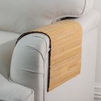 Gather Bamboo Armchair Mat in Natural, featuring smooth bamboo slats draped over the armrest of a light beige upholstered armchair.