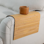 Gather Bamboo Armchair Mat in Natural, styled over a beige armchair with a brown ceramic mug resting on top, showcasing its practical design.
