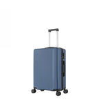bb&b Travel Menton Suitcase in denim blue, shown from a side angle with textured hard-shell exterior, spinner wheels, and an extended handle.