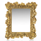 An ornate rectangular wall mirror with a highly detailed, sculpted frame in a textured gold finish, featuring leaf-like or acanthus leaf motifs around the border.