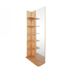 A tall, narrow corner shelving unit with light natural wood shelves and a large clear mirror on the right side, shown on a plain white background.