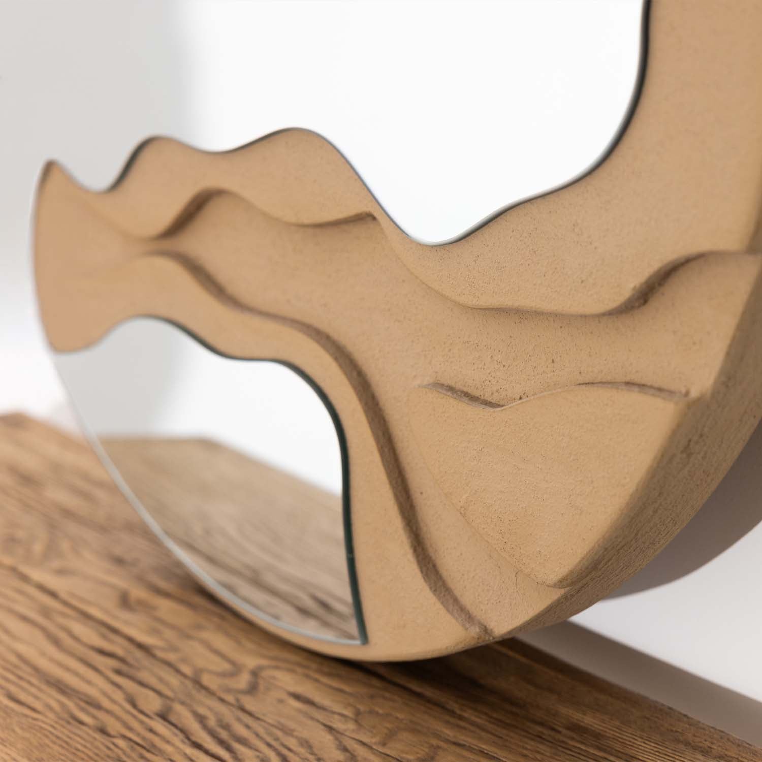 Close-up detail of the Solace Cass Round Mirror showcasing the sculpted natural-toned frame with layered organic contours and integrated mirror sections.