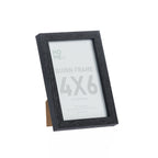 A black woodgrain 4×6 photo frame with a classic rectangular profile and easel back is displayed at an angle against a clean white background.