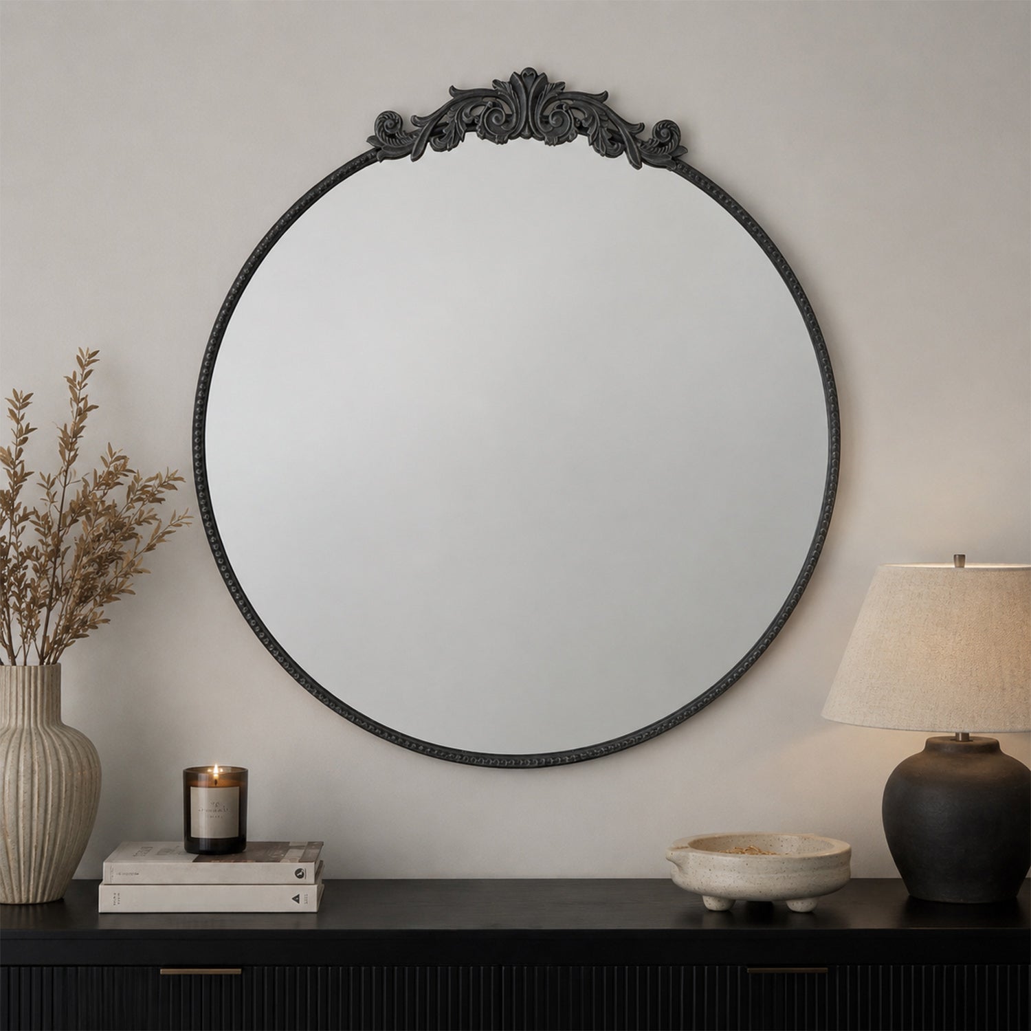 Design Republique Ember Large Round Black Mirror styled above a black console table with a lamp, candle and decorative accents in a contemporary living space.