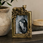 Design Republique Cheetah Gold Photo Frame styled on a dark wooden console table with a ceramic vase, books and decorative accents in a warm contemporary interior.