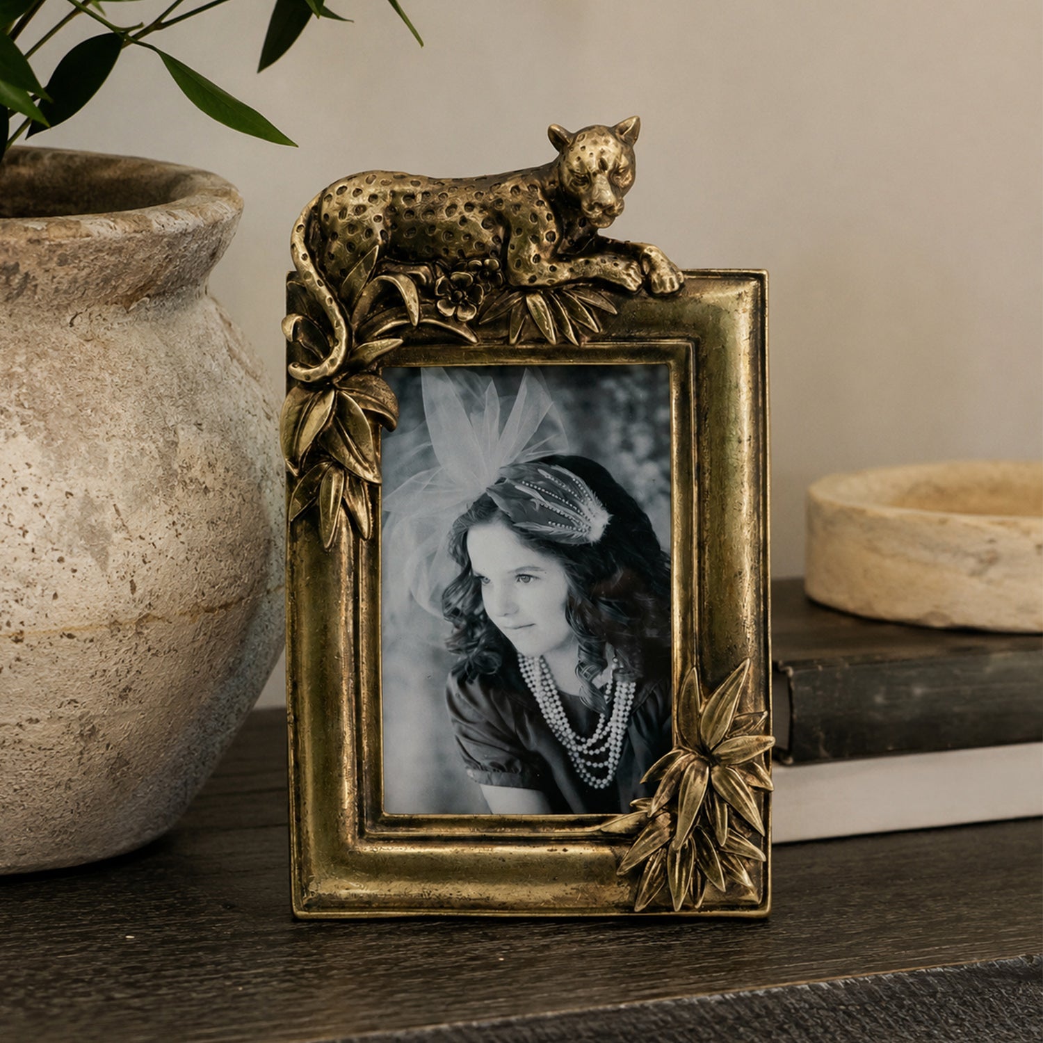Design Republique Cheetah Gold Photo Frame styled on a dark wooden console table with a ceramic vase, books and decorative accents in a warm contemporary interior.