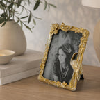 Design Republique Flamingo Small Gold Photo Frame styled on a wooden console table with books, a ceramic vase and soft décor in a warm, elegant home setting.