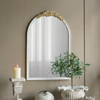 Gracious Living ornate gold trim arched mirror displayed on a taupe wall above decorative home accessories.