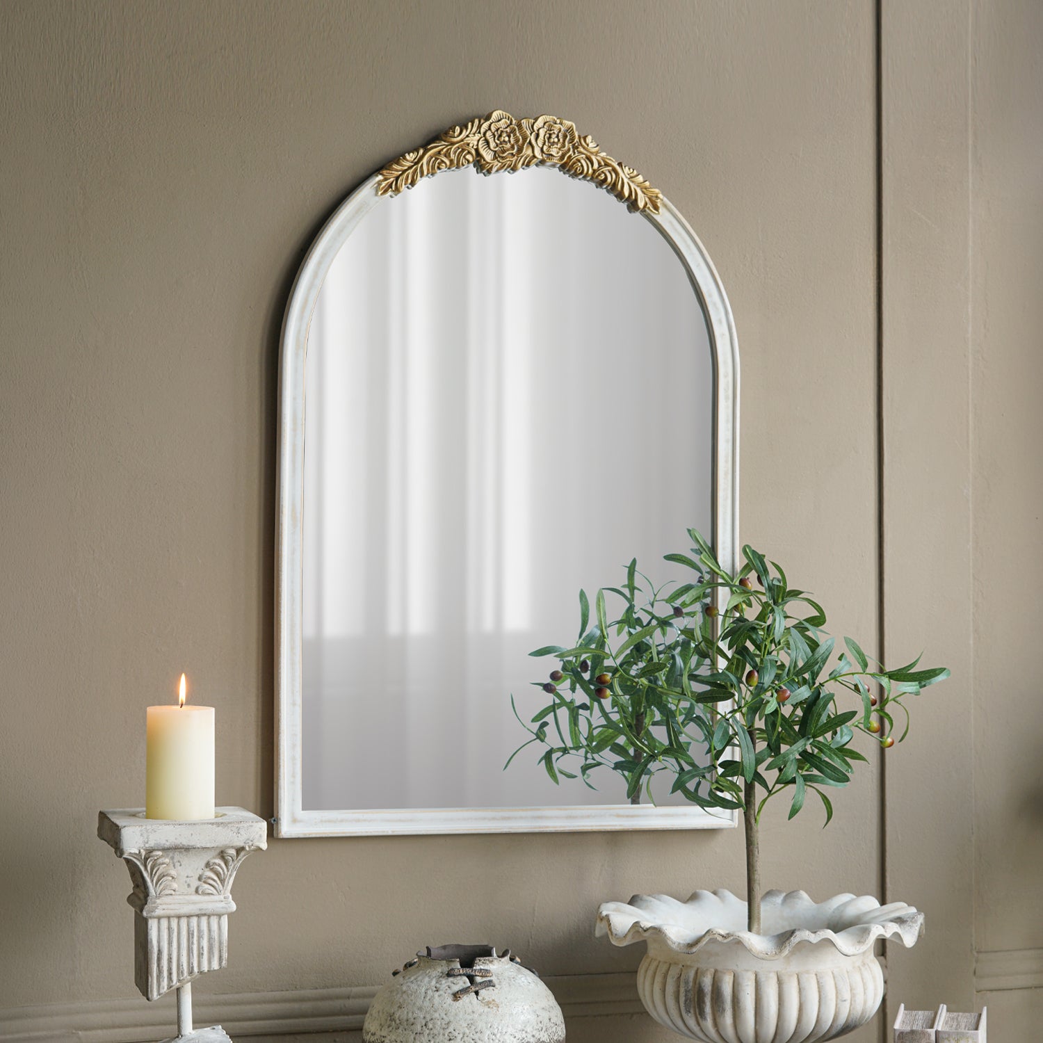 Gracious Living ornate gold trim arched mirror displayed on a taupe wall above decorative home accessories.