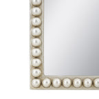 Close-up of the rounded knot-style detailing on the white wash frame of the Cove arched mirror.
