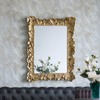 Gracious Living Duchess Mirror displayed on a wall in a styled interior, showing its detailed antique gold floral frame above a dark upholstered sofa.