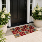 A colourful checkered coir doormat with bold floral tile motifs adds vibrant character and a welcoming touch to this elegant modern entryway, framed by lush white hydrangeas and a black front door.