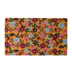 A vibrant floral coir doormat features an all-over pattern of colourful blooms in rich pink, blue, burgundy and green tones on a natural coir background, creating a cheerful and inviting entrance.