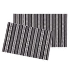 Two rectangular placemats with a black, white, and gray geometric striped pattern, displayed overlapping on a solid white background.