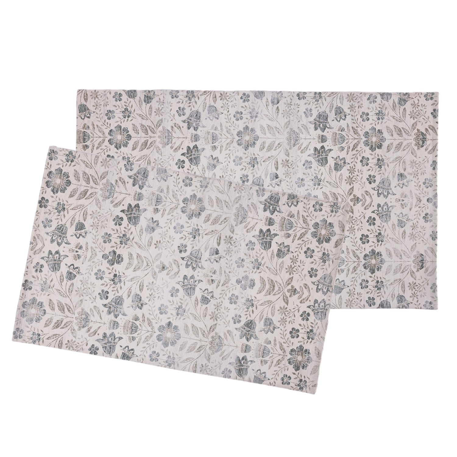 Two rectangular placemats with an all-over floral and leaf pattern in muted blue-gray and beige tones, shown overlapping on a plain white background.