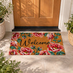 Design Republique Gabriel Floral Welcome Coir Mat featuring colourful red and pink roses, green foliage and black Welcome lettering, placed outside a wooden front door.