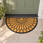 Design Republique Gabriel Semi Rubber Coir Mat in natural featuring a black geometric sunburst pattern, placed on a tiled entranceway in front of a sage green door.