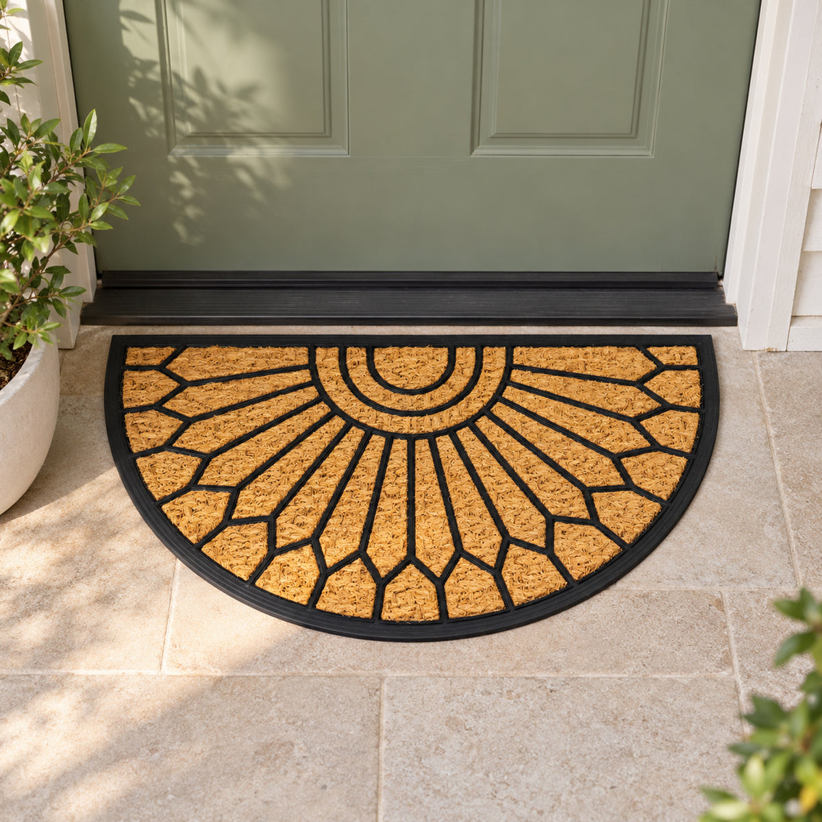 Design Republique Gabriel Semi Rubber Coir Mat in natural featuring a black geometric sunburst pattern, placed on a tiled entranceway in front of a sage green door.