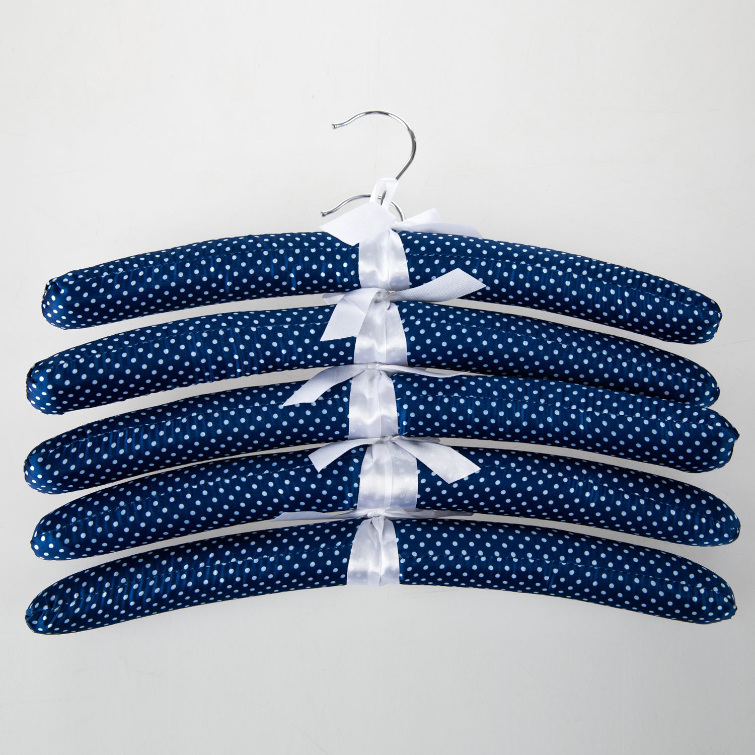Home Essentials Padded Hangers 5 Pack Blue Spots Navy featuring navy padded hangers with a white spot print and ribbon details.