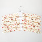 Home Essentials Padded Hangers 5 Pack Flowers Pink featuring cream padded hangers with a pink and orange floral print and ribbon details.