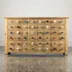 Rustic wooden multi-drawer cabinet featuring an assortment of decorative ceramic, glass and metal drawer knobs in various colours and designs.
