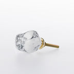 White marble-look stone drawer knob with grey veining detail and gold-tone metal fitting.

