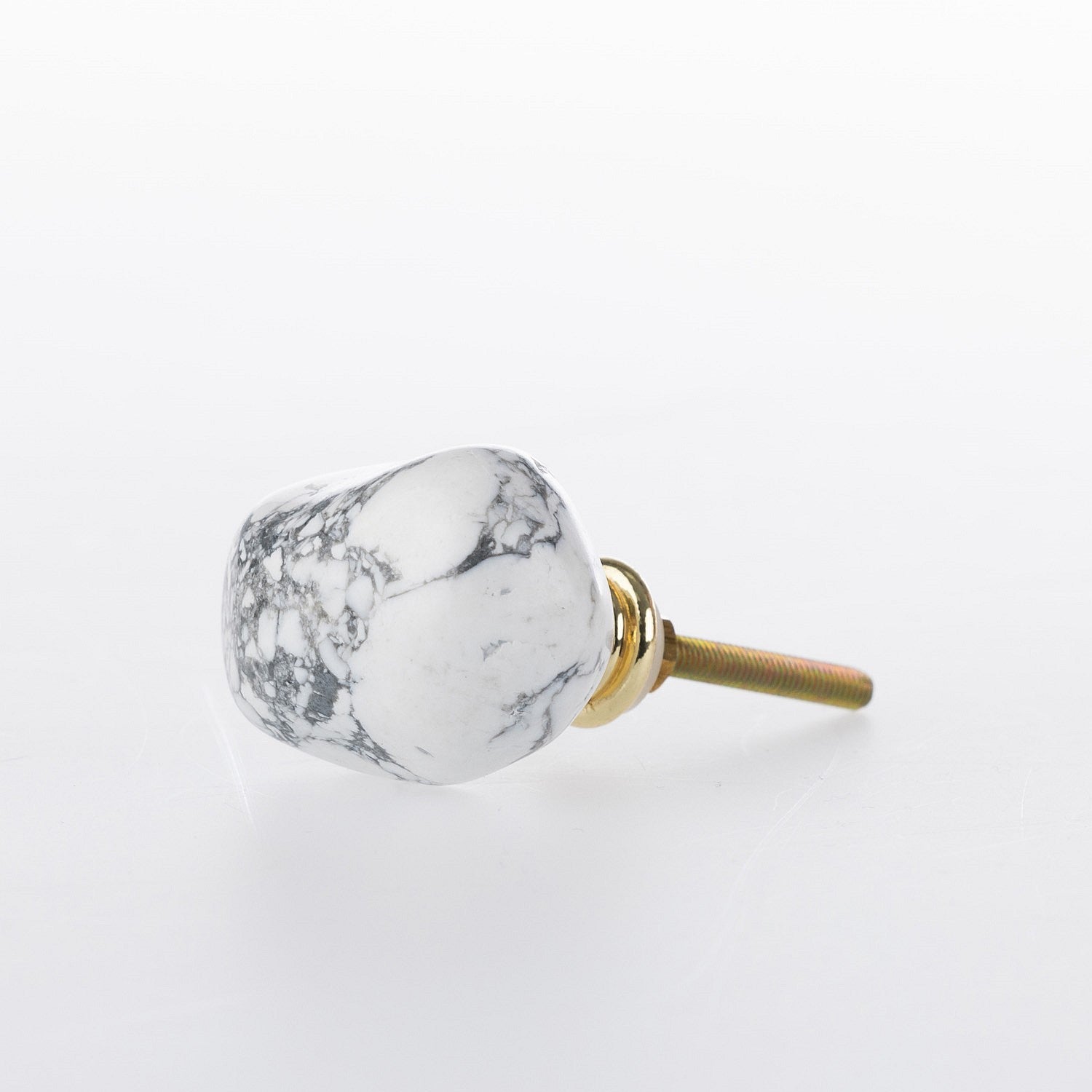 White marble-look stone drawer knob with grey veining detail and gold-tone metal fitting.
