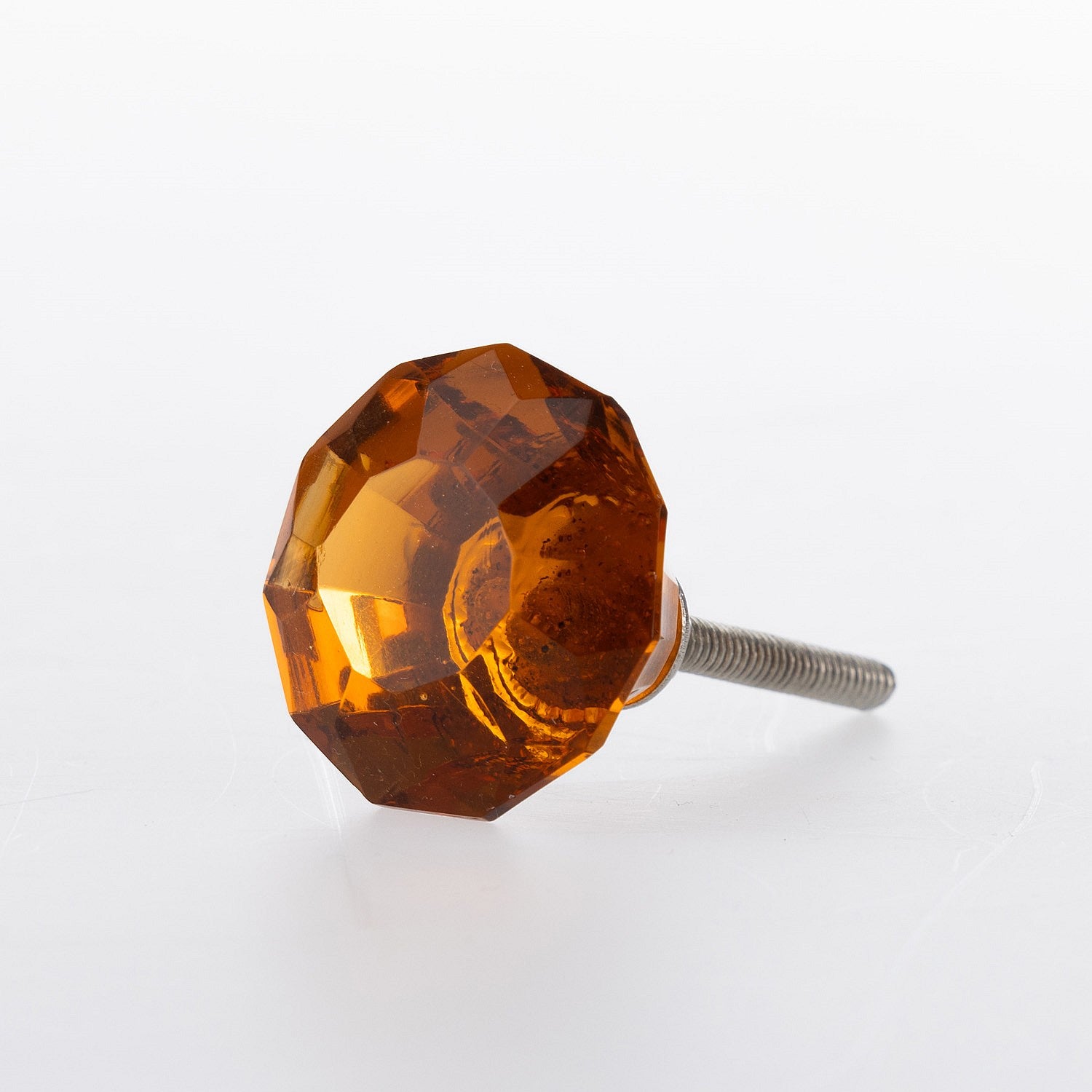 Amber faceted glass drawer knob with jewel-inspired design and metal screw fitting.
