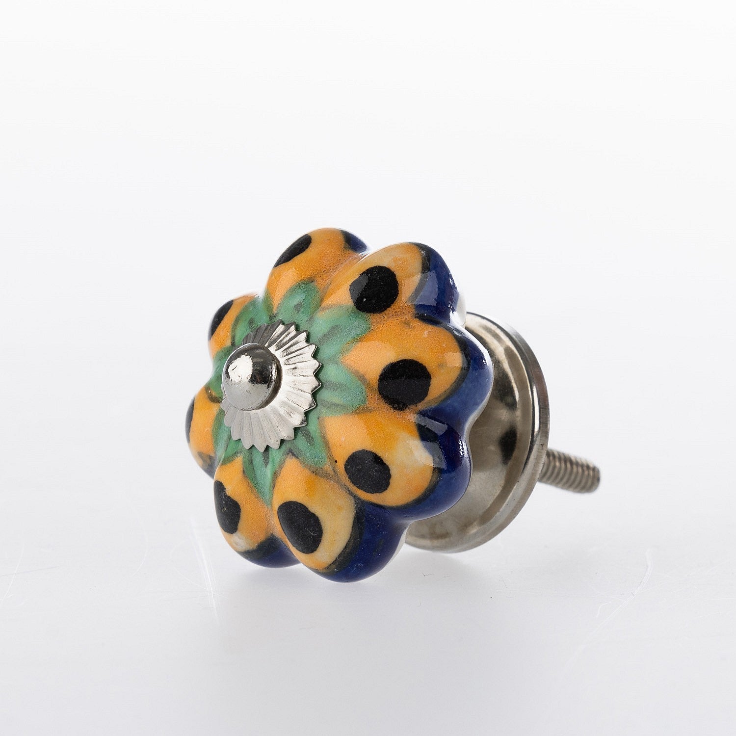Flower-shaped ceramic drawer knob with yellow, green and navy floral pattern detailing and silver metal centre accent.
