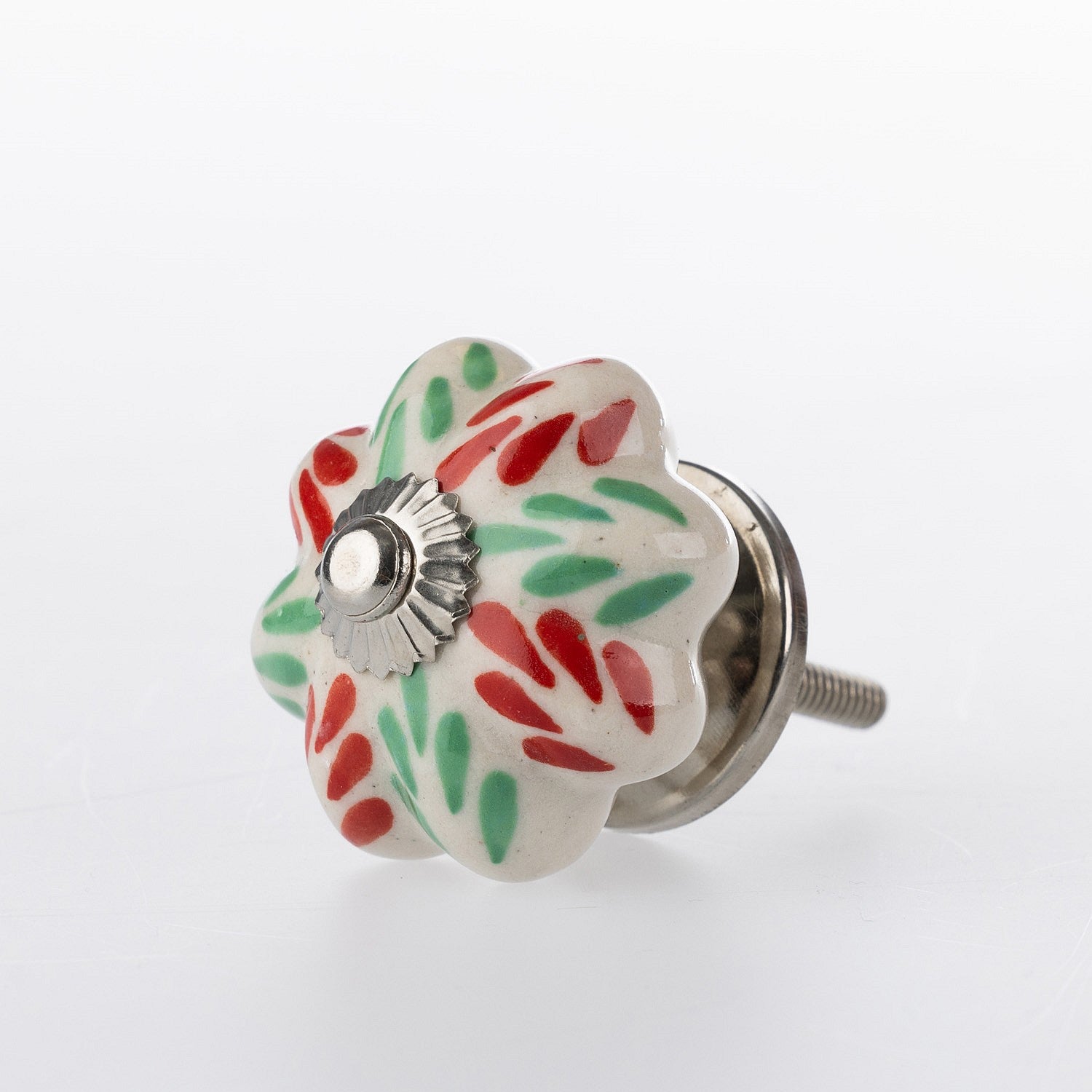 White flower-shaped ceramic drawer knob with red and green floral pattern detailing and silver-tone metal centre accent.