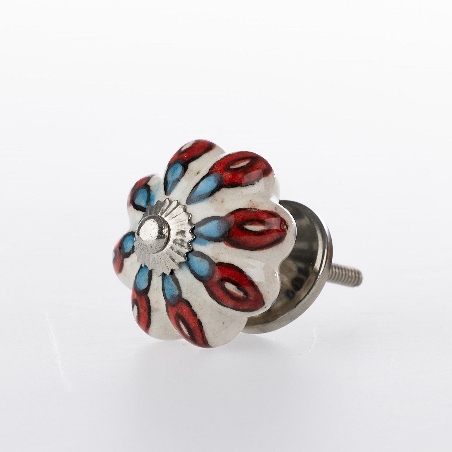 White flower-shaped ceramic drawer knob with red and blue floral pattern detailing and silver metal centre accent.
