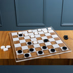Checkers game in progress featuring black and white playing pieces on a clear acrylic checkerboard 
