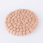 Round woven beige mat on a light gray background