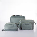 Coordinating blue woven-look cosmetic and vanity bag set with textured finish, zip closures, and gold hardware on a white background.