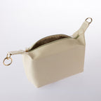 Cream textured cosmetic pouch with gold zip detailing and open top design on a white background.