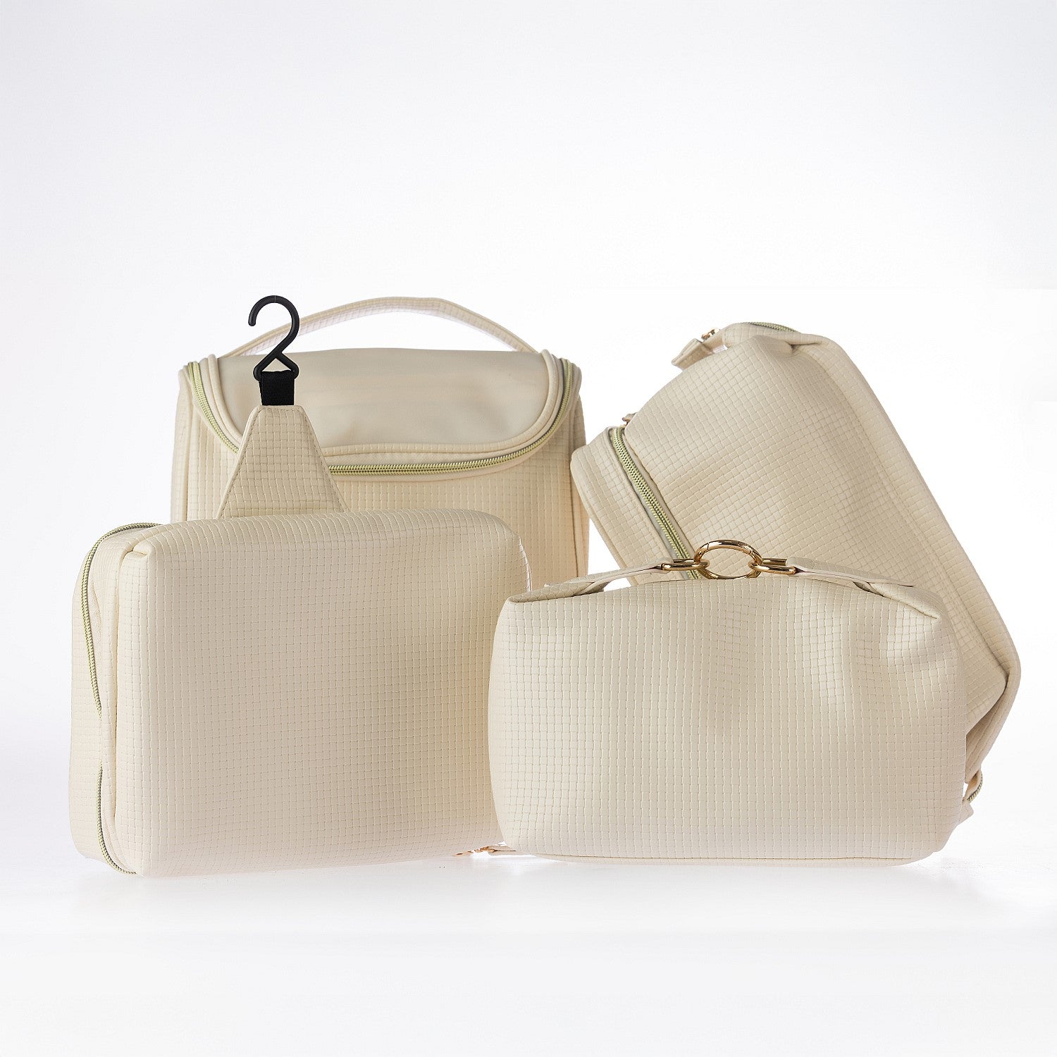 Coordinating cream cosmetic and travel bag set with textured finish and gold hardware displayed together on a white background.