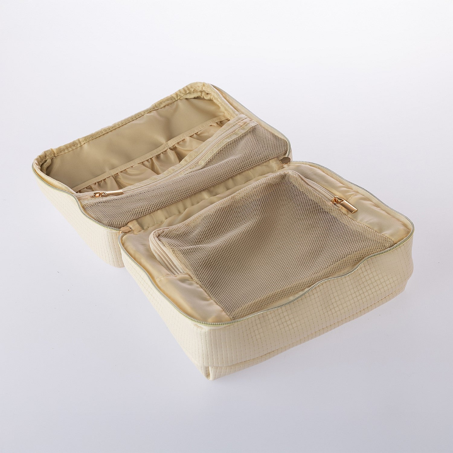 Open cream hanging toiletry bag featuring mesh zip compartments and organised interior storage on a white background.