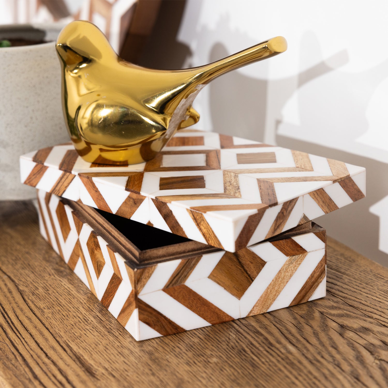 Solace Brie resin jewellery box styled on a wooden surface with a gold bird ornament on top.