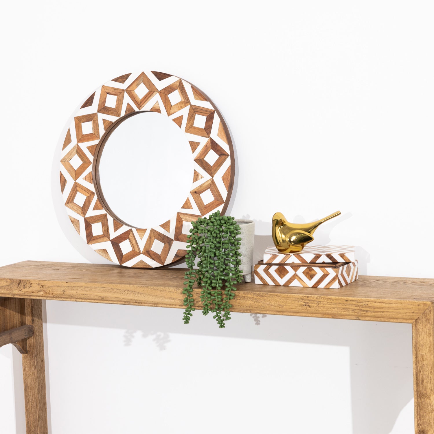 Solace Brie resin jewellery box styled on a wooden console with a matching mirror, plant pot and gold bird ornament.