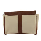Neutral canvas travel organiser with brown trim detailing and structured zip closure on a white background.
