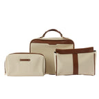 Coordinating neutral canvas cosmetic and travel bag set with brown trim detailing, carry handles, and gold hardware on a white background.

