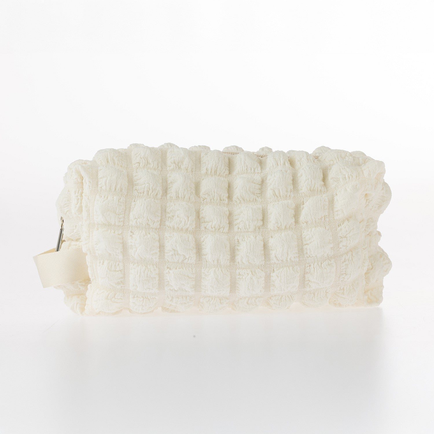 Cream textured waffle toiletry bag with zip closure on a white background.
