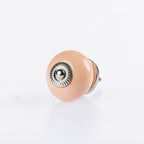 Light Coral round ceramic drawer knob with silver metal centre accent and glossy finish.