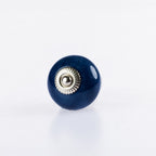 Navy blue round ceramic drawer knob with silver metal centre accent and glossy finish.
