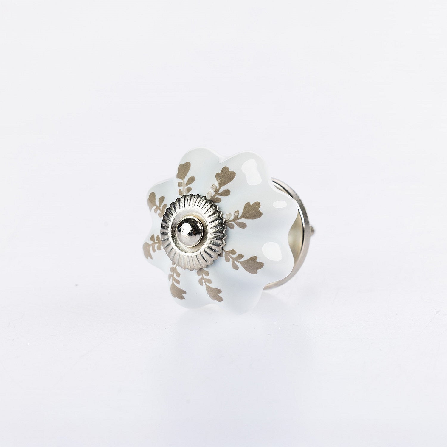 White flower-shaped ceramic drawer knob with taupe leaf detailing and silver metal centre accent.
